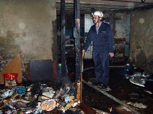 Bild: Wehrführer Hermann-Josef Recktenwald bei der Besichtigung des Brandherdes im Keller des Gebäudes
