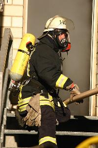 Bild: Durch die starke Rauchentwicklung ist die Sicht in dem Gebäude stark behindert, so dass die Einsatzkräfte ihren Weg nur ertasten können