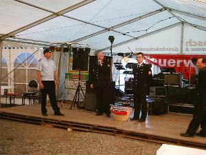 Bild: OLM Hans-Werner Guthörl und OLM Lars Eisenbeis überreichen den Präsentkorb an den Löschbezirksführer Henri Wesnigk.