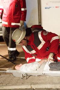 Bild: Erste Untersuchung eines Geretteten vor der brennenden Halle