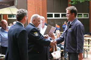 Bild: Gruppenführer Frank Schwan erhält die Auszeichnung stellvertretend für die ganze Gruppe von Kreisbrandinspekteur Werner Thom (Foto: Heinrich Christian Klein, Kreisfeuerwehrverband Neunkirchen)