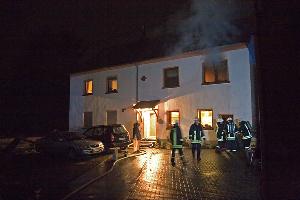 Bild: Situation kurz nach Eintreffen der Feuerwehr: Flammen sind hinter dem Fenster im Obergeschoss zu erkennen