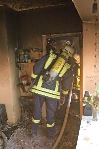 Bild: Feuerwehrleute bei Nachlöscharbeiten im Durchgang zur Küche