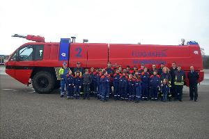 Bild: Gruppenbild mit den Teilnehmern der Besichtigung vor einem der großen Panther-Löschfahrzeuge