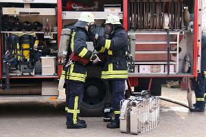 Bild: Ein Trupp bereitet sich mit Atemschutzgeräten für den Einsatz vor