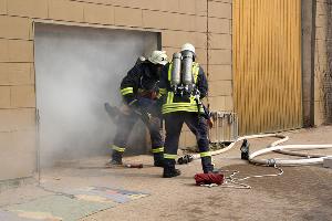 Bild: Eine Person wird aus der völlig verqualmten Maschinenhalle gerettet