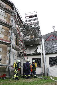 Bild: Aufrichten der Steckleiter, um eine verletzte Person vom Gerüst zu retten