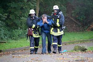 Bild: Ein gehfähiger, verletzter Mitarbeiter wird aus dem Gefahrenbereich gebracht
