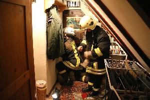 Bild: Putzen des Kamins mit einem Kaminkehrgerät durch die Revisionsklappe