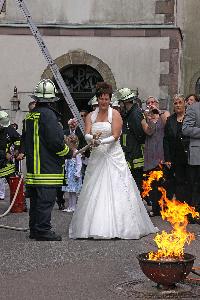Bild: Die Braut beim Löschen des Brandes mit einer Kübelspritze