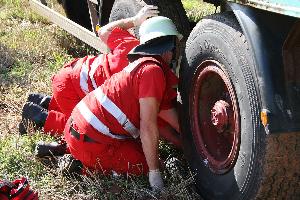 Bild: Der unter dem Anhänger liegende Radfahrer wird von Helfern des DRK medizinisch versorgt