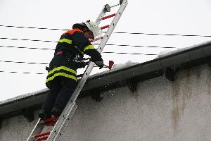 Bild: Mit einem Beil wird das Eis in der Regenrinne entfernt