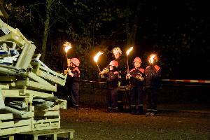 Bild: Jugendfeuerwehrleute werden gleich das Martinsfeuer entzünden