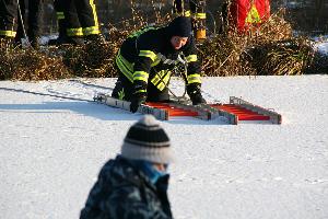 Bild: Um das eigene Gewicht auf eine große Fläche zu verteilen, bewegen sich die Einsatzkräfte auf der Eisfläche mit Steckleiterteilen