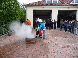 Bild: Nach der Übung: Jugendliche und Betreuer trainieren mit Feuerlöschern an der Übungsanlage