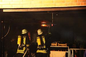 Bild: Einsatzkräfte öffnen die Deckenverkleidung auf der Suche nach Brandnestern