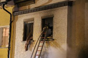 Bild: Ein Trupp geht über eine Steckleiter ins Obergeschoss des Wohnhauses vor