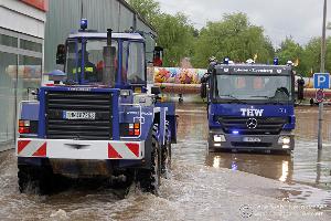Bild: Bei der Sicherung eines notgedrungen im Blieshochwasser zurückgelassenen Autoscooters auf dem Wiebelskircher Festplatz arbeiten Feuerwehren aus Neunkirchen und Bildstock, das DLRG aus Eppelborn und Illingen sowie das THW aus Spiesen-Elversberg Hand in Hand zusammen. (Foto: Christopher Benkert - Feuerwehr Neunkirchen)
