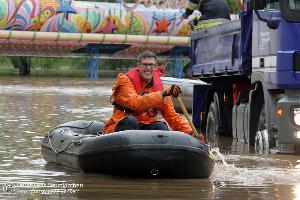 Bild: Bei der Sicherung eines notgedrungen im Blieshochwasser zurückgelassenen Autoscooters auf dem Wiebelskircher Festplatz arbeiten Feuerwehren aus Neunkirchen und Bildstock, das DLRG aus Eppelborn und Illingen sowie das THW aus Spiesen-Elversberg Hand in Hand zusammen. (Foto: Christopher Benkert - Feuerwehr Neunkirchen)