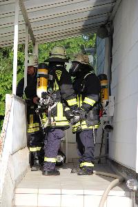 Bild: Ein Trupp mit Atemschutzgeräten vor dem Eingang zum Gebäude