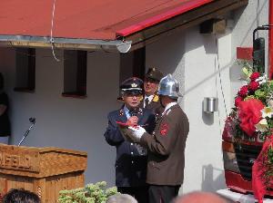 Bild: Löschbezirksführer Wolfgang Braun überreicht ein Gastgeschenk nach seiner Ansprache