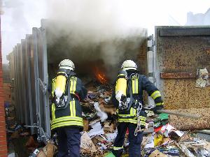 Bild: Ablöschen des Inhaltes nach dem Öffnen des Containers unter Atemschutz
