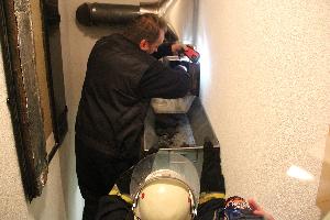 Bild: Ausräumen von Glutresten durch den Schornsteinfeger